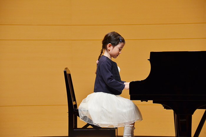 ピアノの目標達成に向け練習する子供